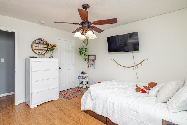 bedroom featuring a ceiling fan, baseboards, and light wood finished floors