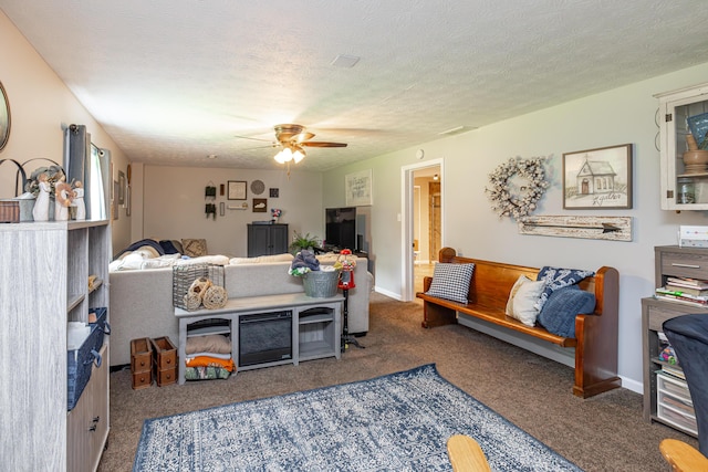 living room with ceiling fan, baseboards, a textured ceiling, and carpet flooring