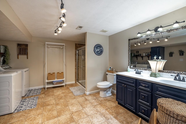 full bath with a sink, washing machine and dryer, and visible vents