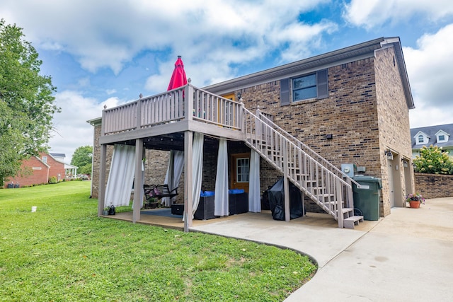 back of property with brick siding, a lawn, a patio area, a wooden deck, and stairs