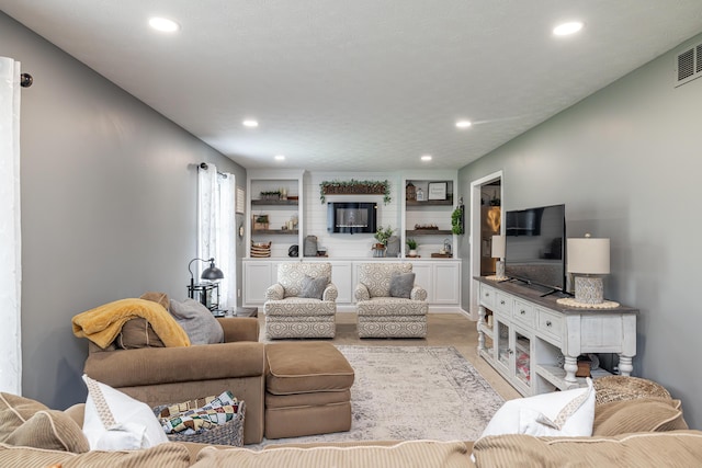 living room featuring built in shelves, visible vents, and recessed lighting