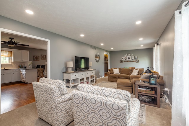 living area with baseboards, visible vents, ceiling fan, wood finished floors, and recessed lighting