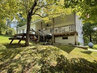 rear view of property with ceiling fan, a lawn, and a wooden deck