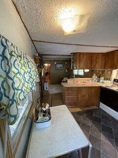 kitchen featuring stove, a textured ceiling, and tile patterned flooring