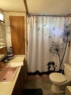 bathroom featuring sink, toilet, and tile patterned flooring