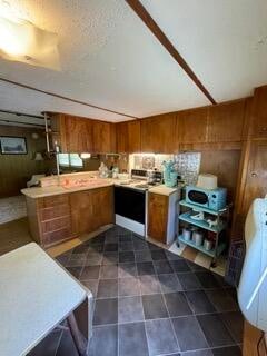 kitchen with dark tile patterned floors and range with electric stovetop