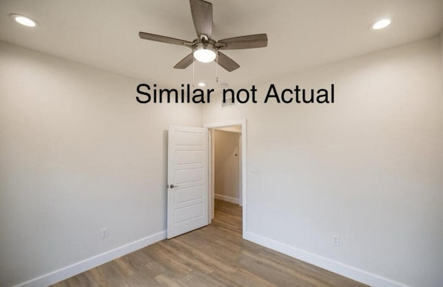 spare room with ceiling fan and hardwood / wood-style flooring