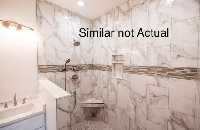 bathroom with vanity and tiled shower