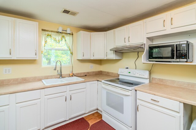 kitchen with sink, light wood-type flooring, white cabinetry, and electric stove