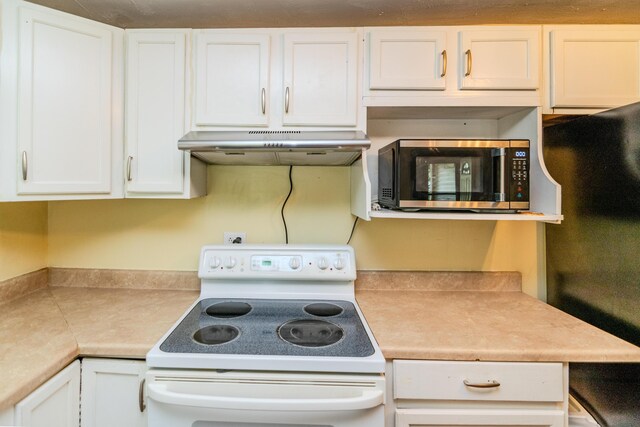 kitchen with exhaust hood, electric stove, and white cabinetry