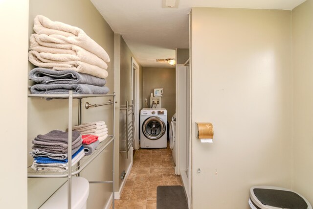 washroom with light tile patterned floors and washer and dryer