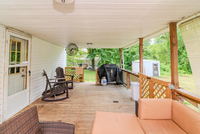 wooden deck featuring a storage shed and grilling area