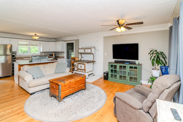 living room featuring light wood-type flooring, crown molding, and ceiling fan