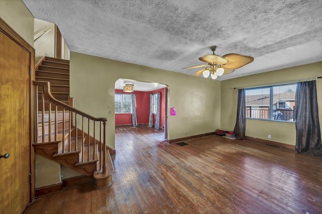 interior space featuring ceiling fan, wood-type flooring, and a textured ceiling