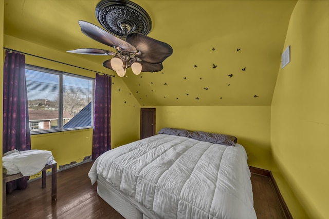 bedroom featuring dark hardwood / wood-style flooring, lofted ceiling, and ceiling fan