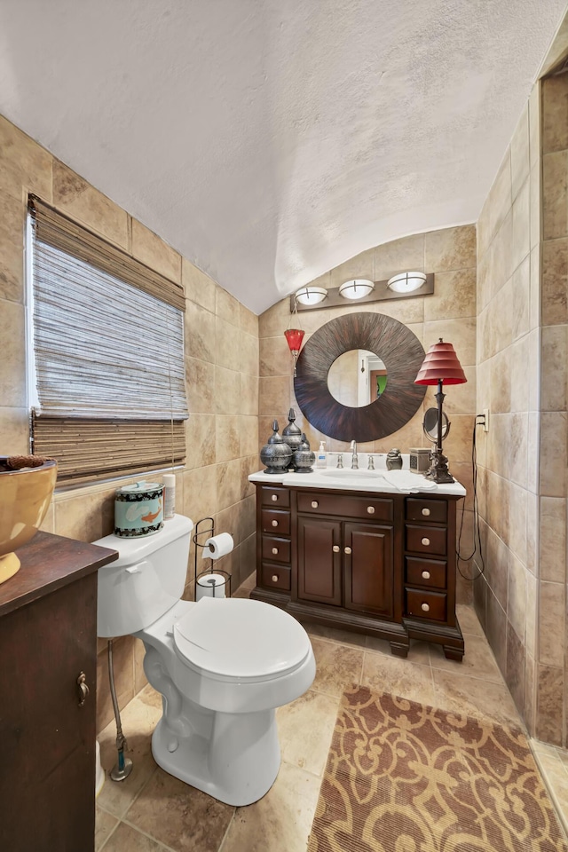 bathroom featuring tile walls, a textured ceiling, vaulted ceiling, and toilet