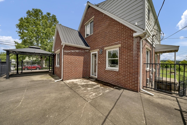 view of property exterior featuring a gazebo and a patio area