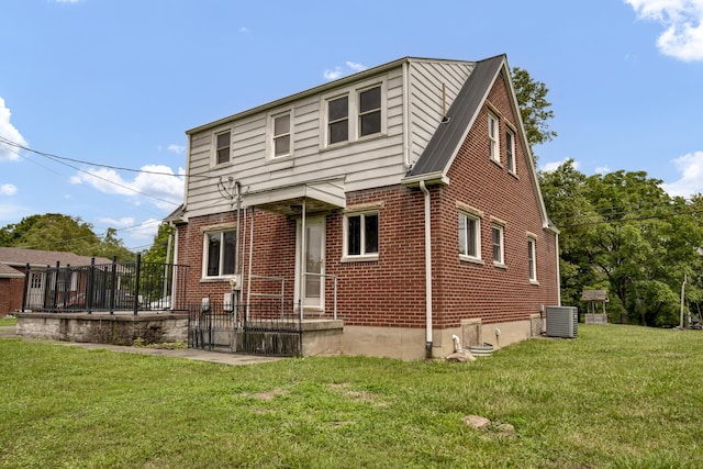 rear view of property featuring cooling unit and a yard