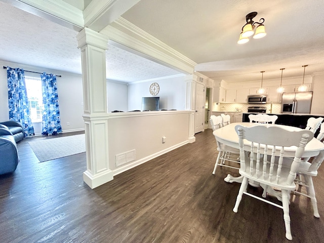 dining room with crown molding, dark hardwood / wood-style floors, a textured ceiling, and ornate columns