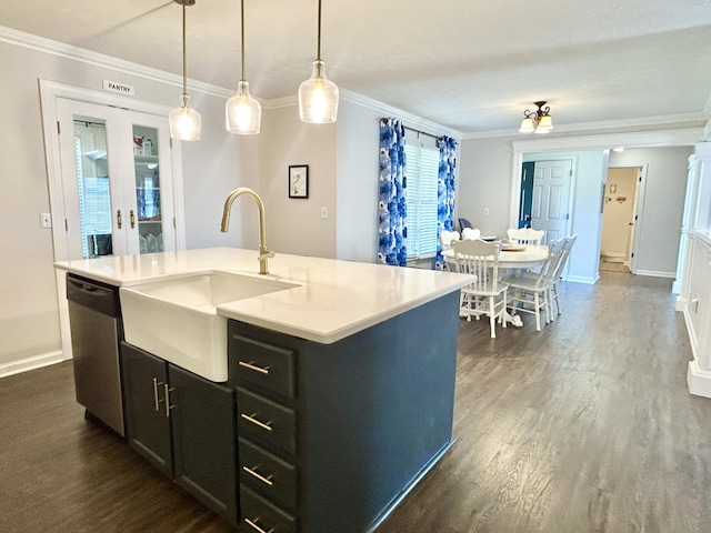 kitchen featuring sink, decorative light fixtures, stainless steel dishwasher, ornamental molding, and an island with sink