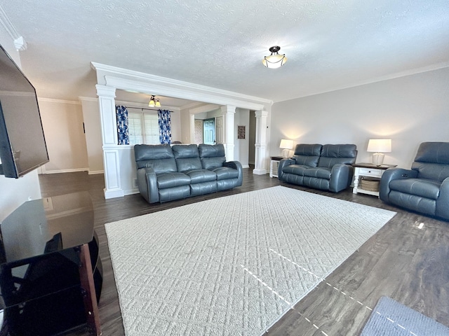 living room featuring dark hardwood / wood-style flooring, crown molding, and decorative columns