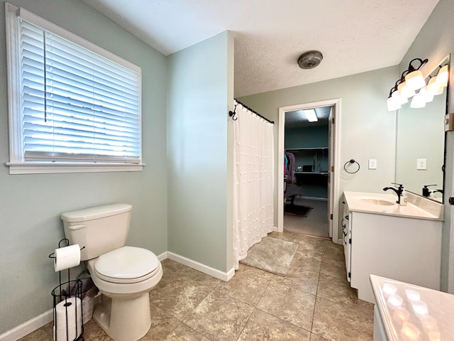 bathroom featuring vanity, a textured ceiling, and toilet