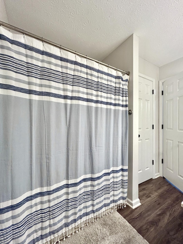 bathroom with hardwood / wood-style floors and a textured ceiling