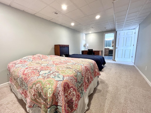 bedroom with a paneled ceiling and light carpet