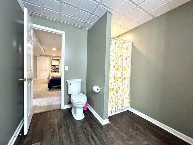 bathroom featuring a shower with curtain, hardwood / wood-style floors, and toilet