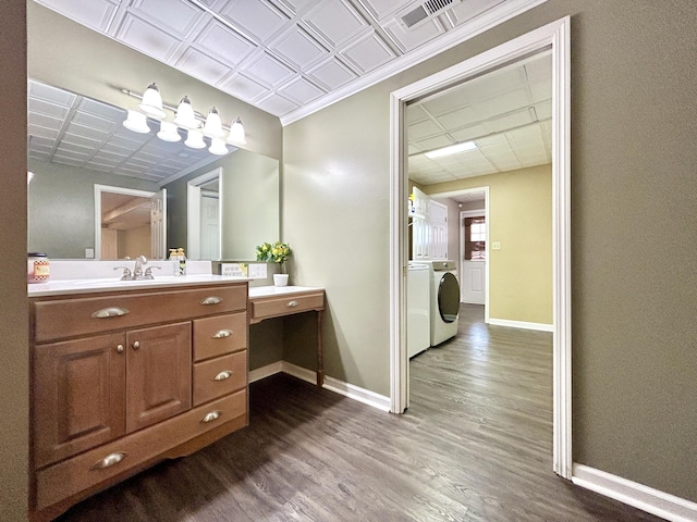 bathroom featuring vanity, hardwood / wood-style flooring, and washing machine and dryer