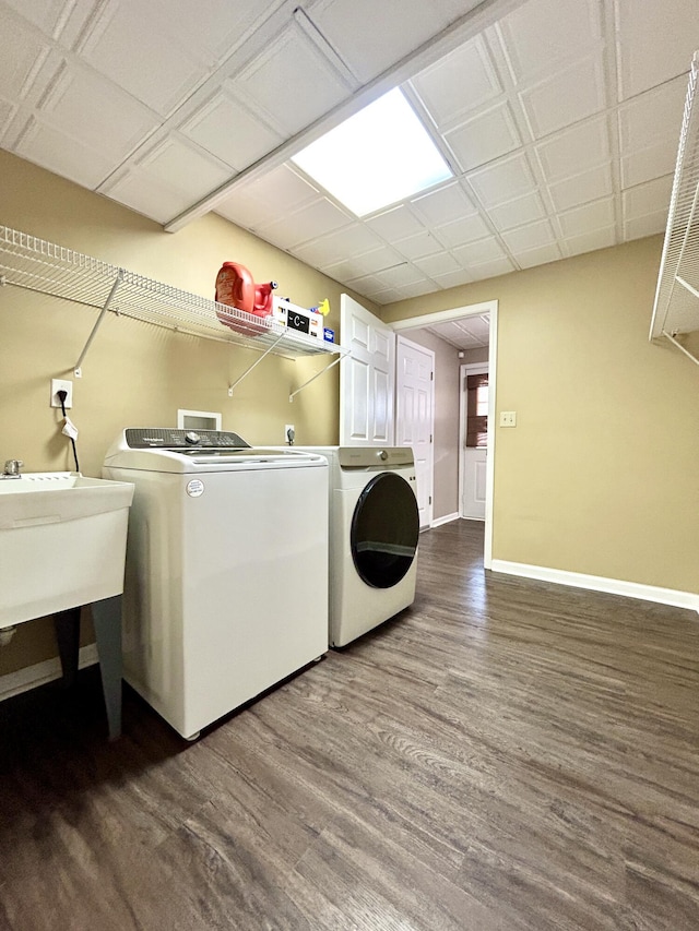 laundry room with sink, washing machine and clothes dryer, and dark hardwood / wood-style flooring