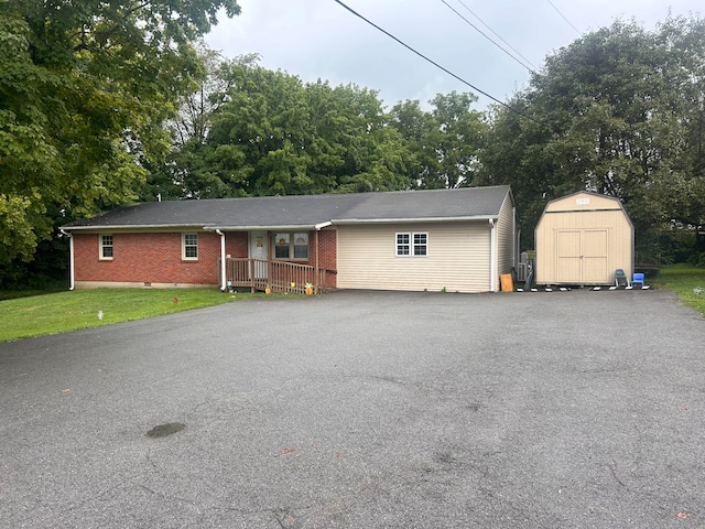 ranch-style home with a shed and a front lawn