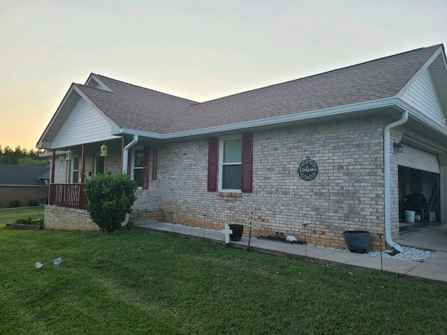 exterior space with a garage, a porch, and a lawn