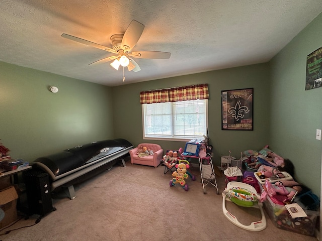 recreation room featuring a textured ceiling, carpet, and ceiling fan