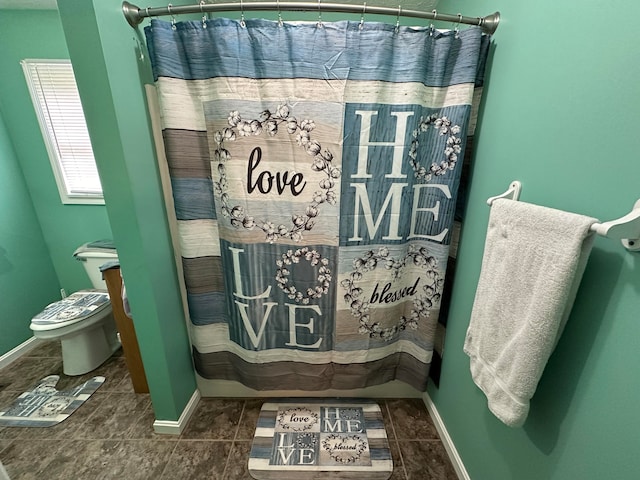 interior space featuring a shower with curtain and toilet