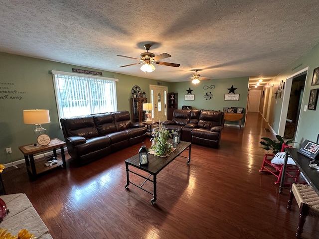 living room featuring ceiling fan, dark hardwood / wood-style flooring, and a textured ceiling