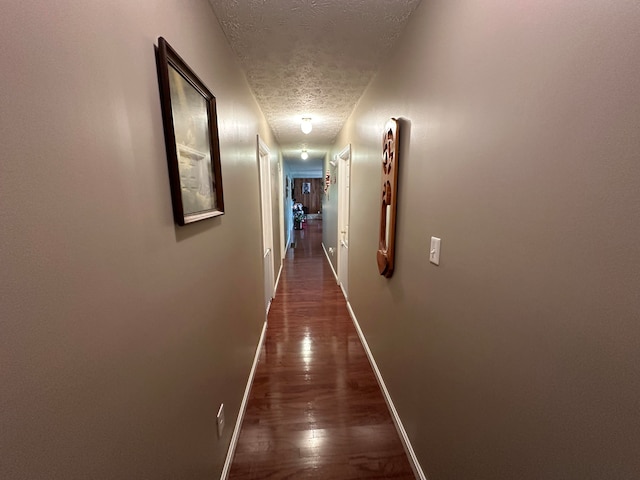 hallway featuring dark hardwood / wood-style floors and a textured ceiling