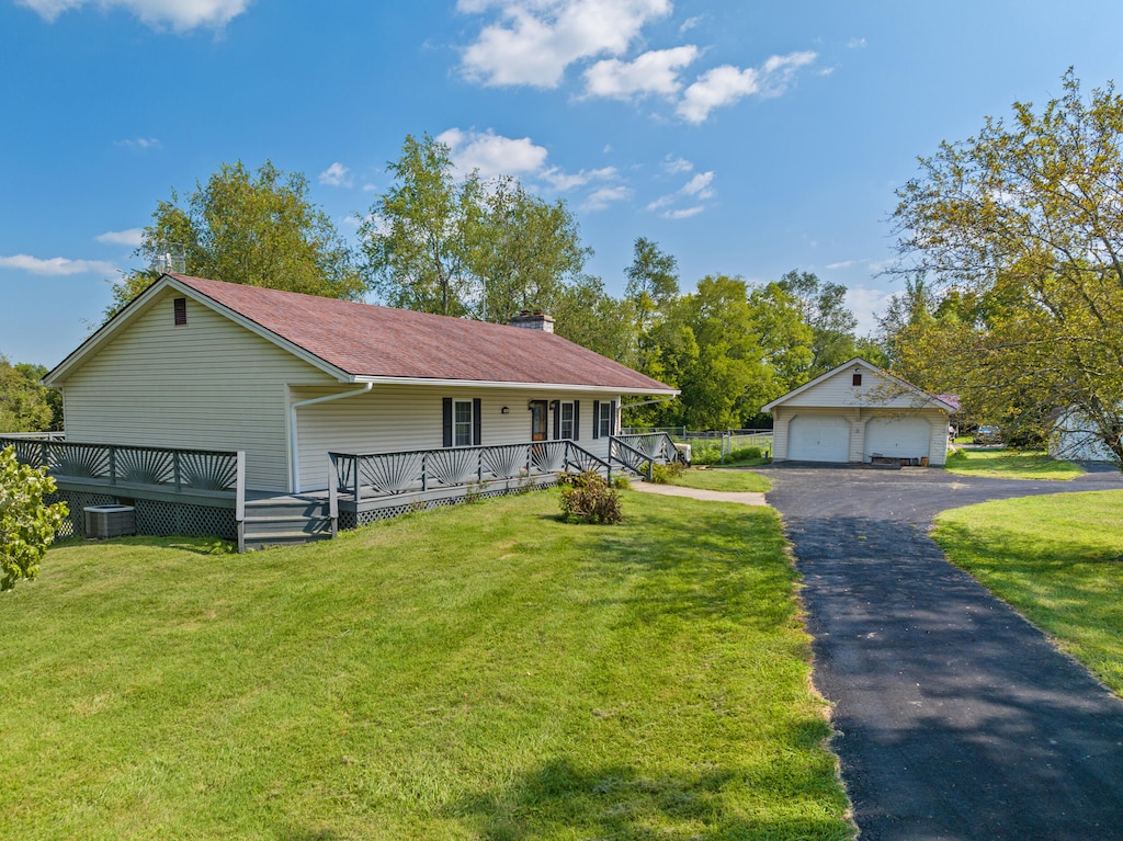 view of front of property with a garage, central AC, and a front lawn