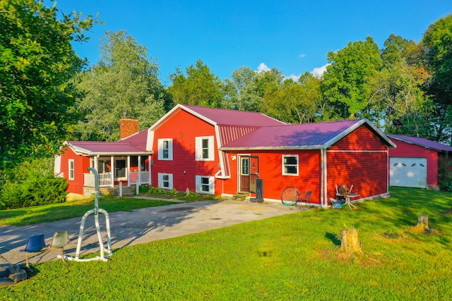 back of property with a lawn, an outdoor structure, a porch, and a garage