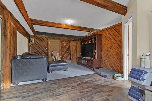 living room with wood-type flooring, beamed ceiling, and wooden walls