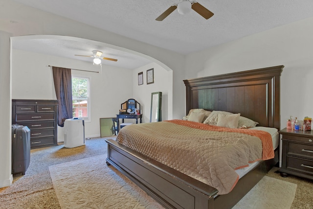 carpeted bedroom featuring ceiling fan and a textured ceiling