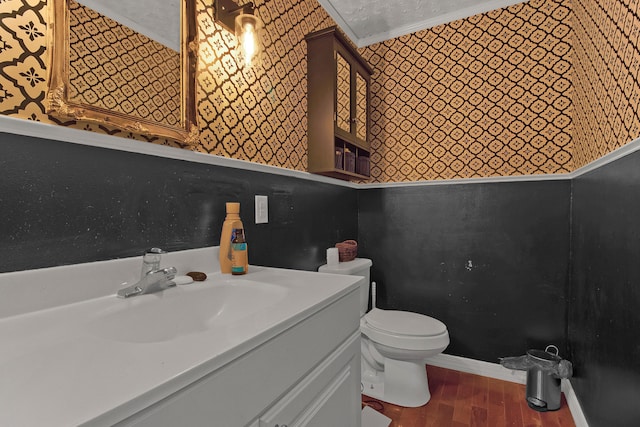 bathroom with toilet, vanity, hardwood / wood-style floors, crown molding, and a textured ceiling