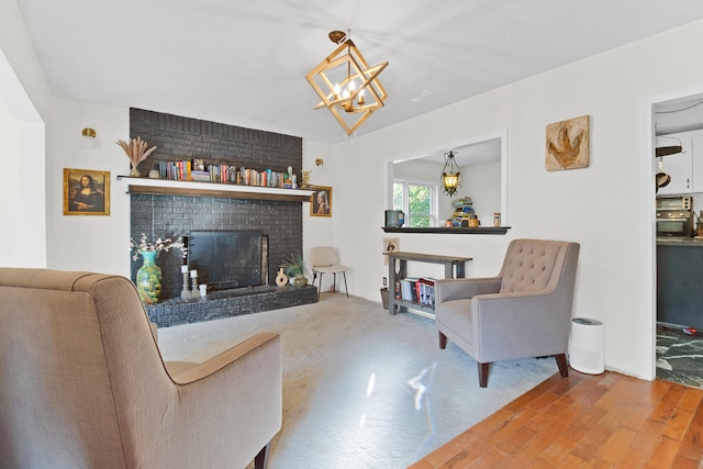 living room featuring an inviting chandelier, a fireplace, and hardwood / wood-style floors