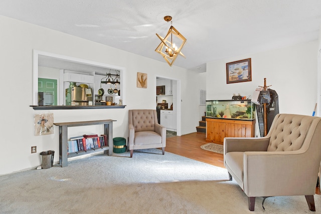 living area featuring light colored carpet, a textured ceiling, and a notable chandelier