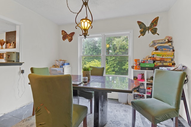 dining room with a textured ceiling and light tile patterned floors