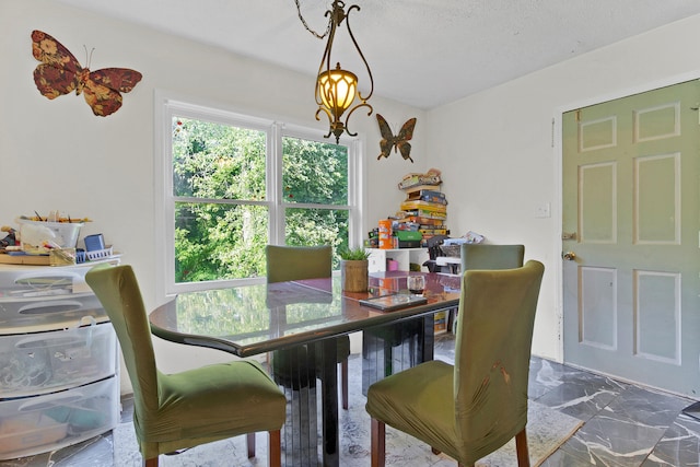 dining space featuring a textured ceiling and an inviting chandelier