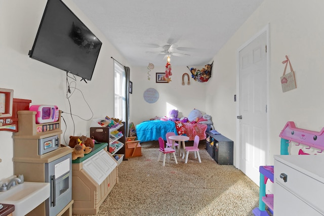 playroom with ceiling fan, carpet, sink, and a textured ceiling