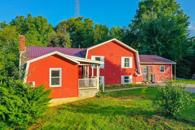 rear view of property with a lawn and a porch