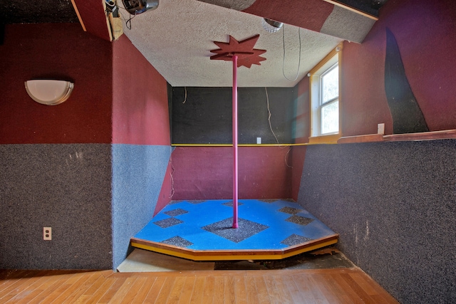 bathroom with a textured ceiling and hardwood / wood-style flooring