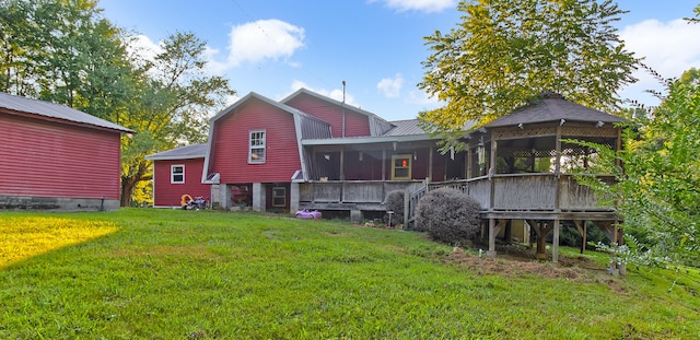 rear view of house featuring a sunroom and a yard